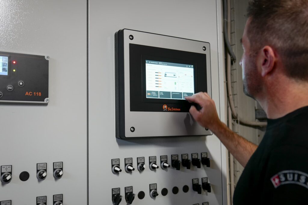 Le paysan Joël est en train de régler quelque chose sur une machine.