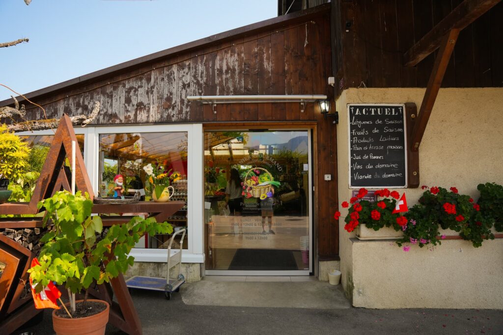 La magasin de la ferme de Nicolas Heuberger vu de l'extérieur. Le logo et les horaires d'ouverture sont visibles sur la porte vitrée.